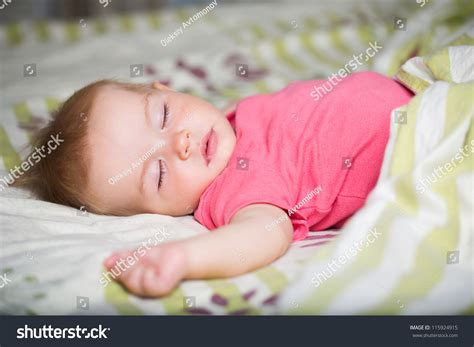 Cute Baby Girl Sleeping Laying On A White Green Blanket