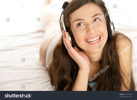 Young Woman Listening To Music Lying Down On Bed Royalty Free Stock