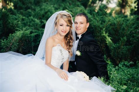 Bride Sit Together With Groom On Green Grass Park Stock Image Image