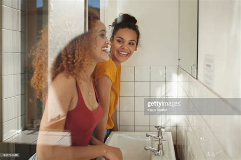 Friends Getting Ready In Front Of Mirror In Bathroom Photo Getty Images
