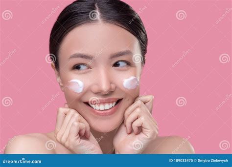 Mulher Sorridente Tomando Creme Facial Em Seus Ossos Da Bochecha Imagem De Stock Imagem De