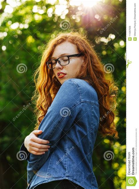 Sensual Red Haired Girl In Glasses Posing In Rays Of Sun At The Stock