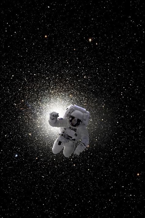 Astronaut Floating In Deep Space With Large Cluster Galaxy In