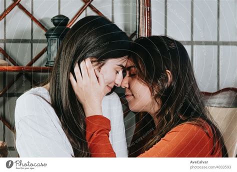 ein lesbisches paar über zu küssen einander auf eine schöne aufnahme in einer modernen wohnung