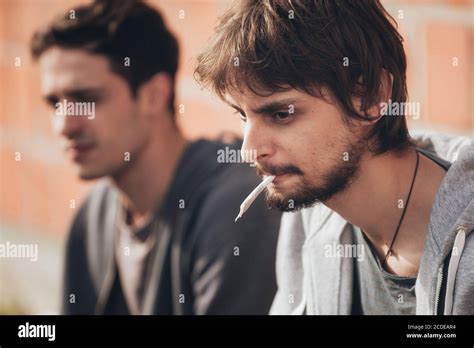 Depressed And Sad Young Man Smoking Cannabis Or Hashish Joint With His