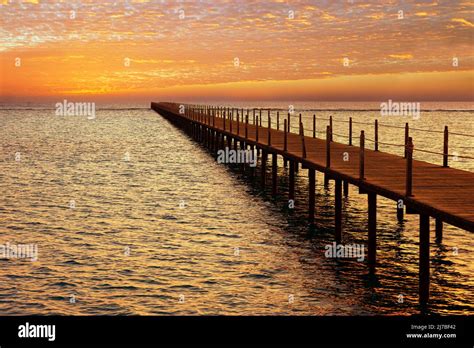 Wooden Pontoon Bridge In Sea And Picturesque Sky With Spindrift Clouds