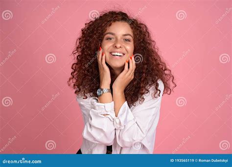 Pretty Cheerful Redhead Girl With Flying Curly Hair Smiling Laughing Looking At Camera Over Pink