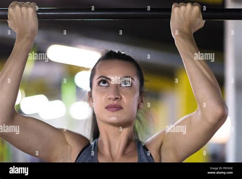 Young Muscular Woman Doing Pull Ups On The Horizontal Bar As Part Of