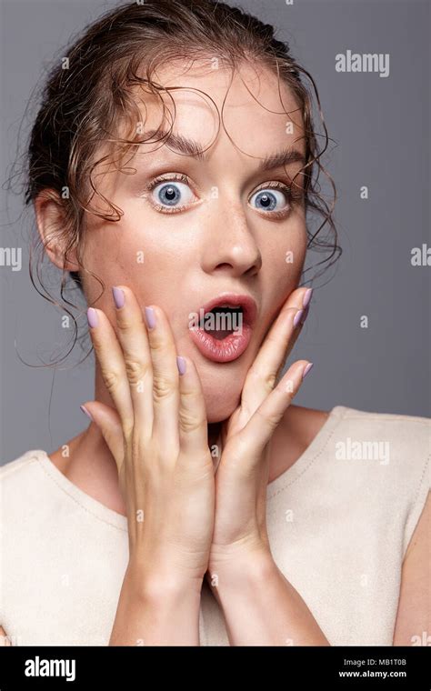 Amazed Young Woman With Hands Near Face And Mouth Open Shocked Girl With Bulging Eyes