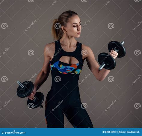 Strong Fit Woman Exercising With Dumbbells Isolated On Grey Background