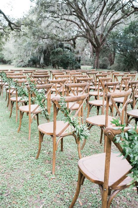 Why does renting chairs have to fall into that same catergory? Greenery adorned wedding ceremony chairs at an outdoor ...