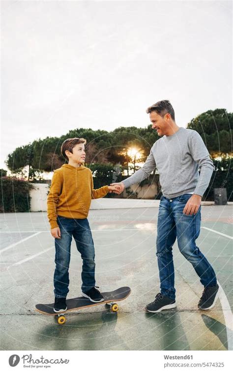 Vater Assistiert Sohn Beim Skateboardfahren Ein Lizenzfreies Stock