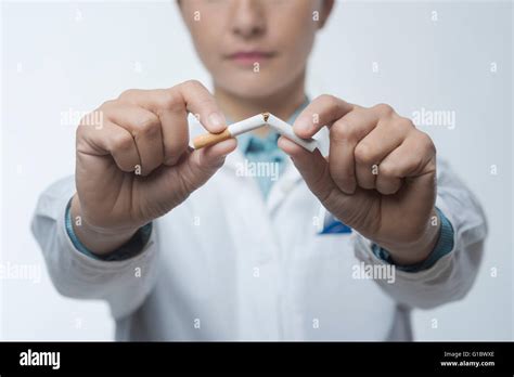 Stop Smoking Concept With Female Doctor Breaking A Cigarette Stock