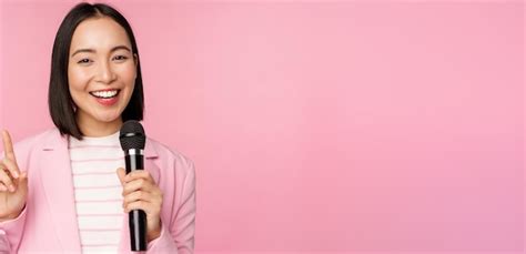 free photo image of enthusiastic asian businesswoman giving speech talking with microphone