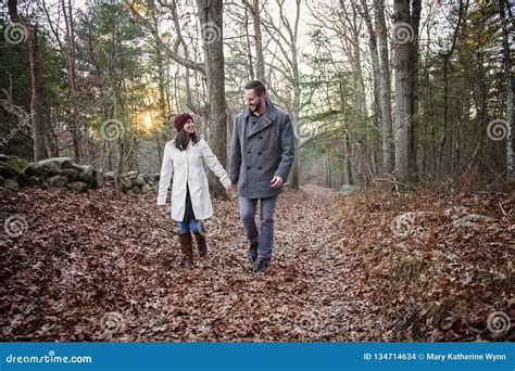 Romantic Young Couple Holding Hands Walking In The Woods Stock Photo