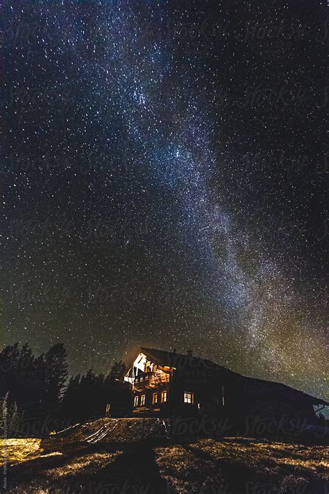 Alpine Cabin In The Mountains At Night With The Milky Way Above By