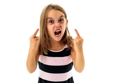 premium photo portrait of angry girl showing obscene gesture while standing against white