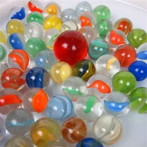 Many Different Colored Marbles On A White Plate