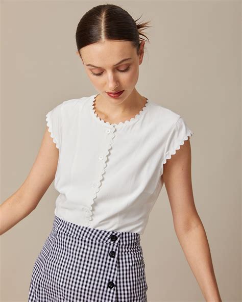 Details:- Scalloped- Solid Color- Cap Sleeve- Round Neck- Button Up