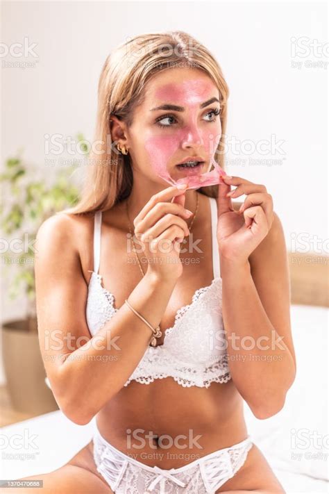 Beautiful Blonde Girl Applies Pink Peeling Mask On Her Face Indoors