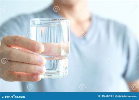 In The Morning Hand Of Man Holding A Clear Glass Of Water For Drinking