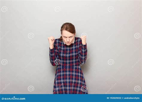 Portrait Of Angry Furious Young Woman Raising Both Fists Up Stock Photo