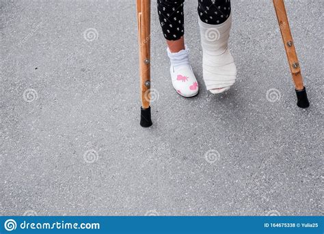 Little Girl With Crutches Walking Outdoor Back To Schoolleg In Cast