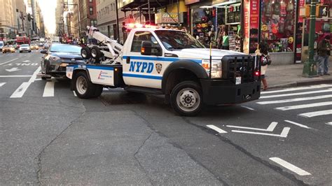 Nypd Tow Truck Towing A Car On 8th Avenue In The Midtown Area Of