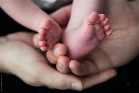 Close Up Of Parent S Hands Cradling Newborn Son S Feet By Stocksy Contributor Holly Clark