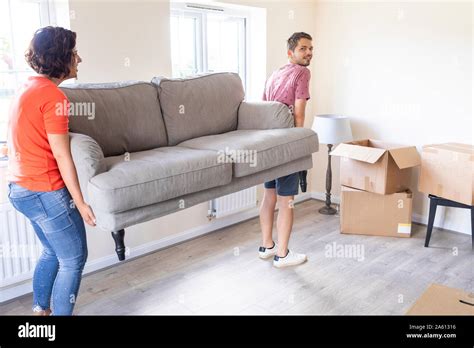 Couple Moving Into New Home Carrying A Sofa Stock Photo Alamy