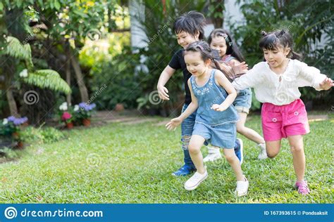 Asian Kids Playing Outdoors With Friends. Little Children  