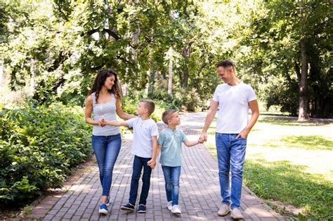 Familia De Cuatro Personas A Pasear Por El Parque Foto Gratis