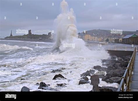 Dramatic Waves Smashing Against The Sea Wall And Being Forced High Into