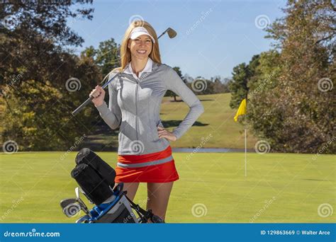 lovely blonde female golfter enjoying a round of golf on a public golf course stock image