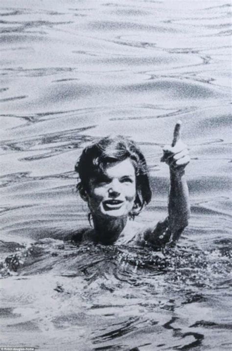 A Woman In The Water Holding Up A Stick