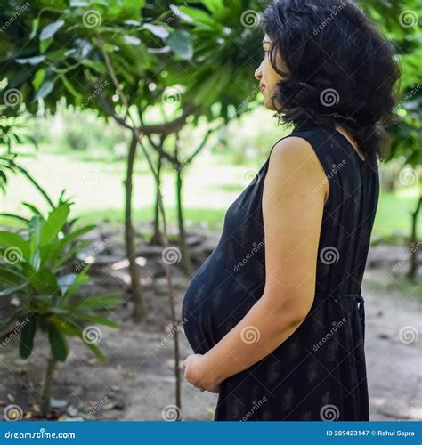 A Pregnant Indian Lady Poses For Outdoor Pregnancy Shoot And Hands On Belly Indian Pregnant