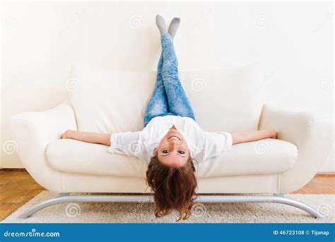 Woman Lying Upside Down On A Sofa Royalty Free Stock Image