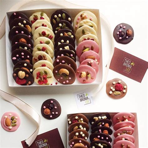 A Box Filled With Assorted Donuts Next To A Card And Other Items On A Table