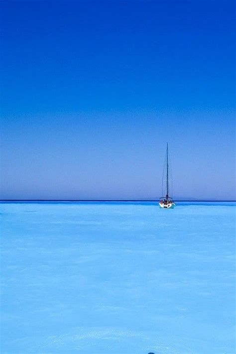 Two Boats Floating In The Ocean On A Clear Day With Blue Sky And Water