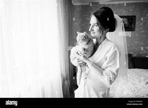 Bride Posing With Her Cat Inside Her House Before The Wedding Ceremony