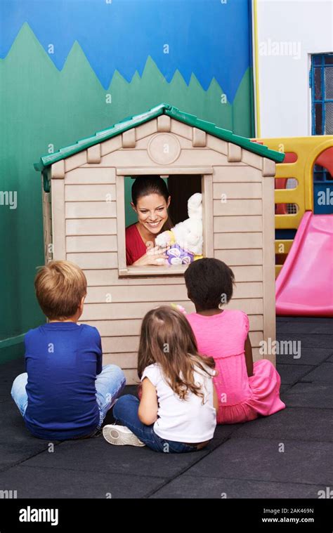 Woman Plays Puppet Theater In Kindergarten In Front Of A Group Of