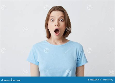 Closeup Of Shocked Stunned Young Woman In Blue T Shirt With Opened Mouth Feels Amazed And Looks
