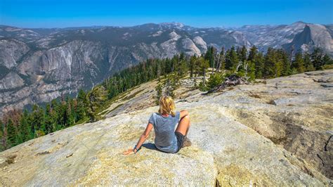 Hiker Resting At The Top Of Sentinel Dome In Yosemite Yosemite