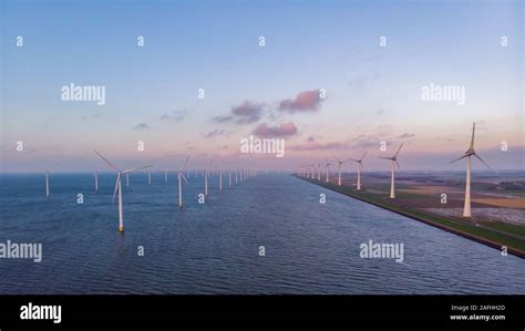 Windmill Park Green Energy During Sunset In The Ocean Offshore Wind