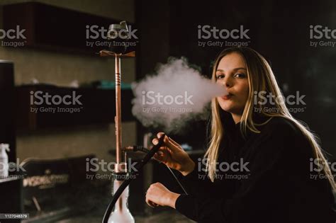 Young Caucasian Blonde Girl Smoking Hookah At Luxury Interior With
