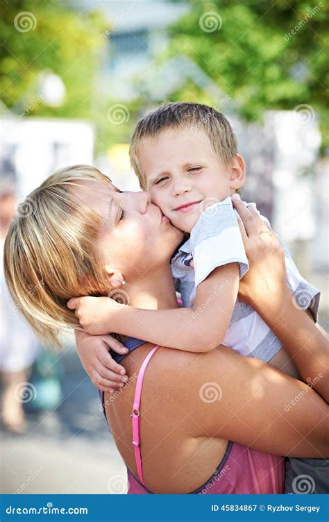 Счастливая мать целует ее сына Стоковое Изображение изображение насчитывающей отдыхать сынок