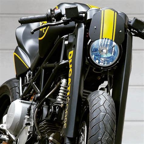 The Front End Of A Black Motorcycle With Yellow Stripes On Its Fenders