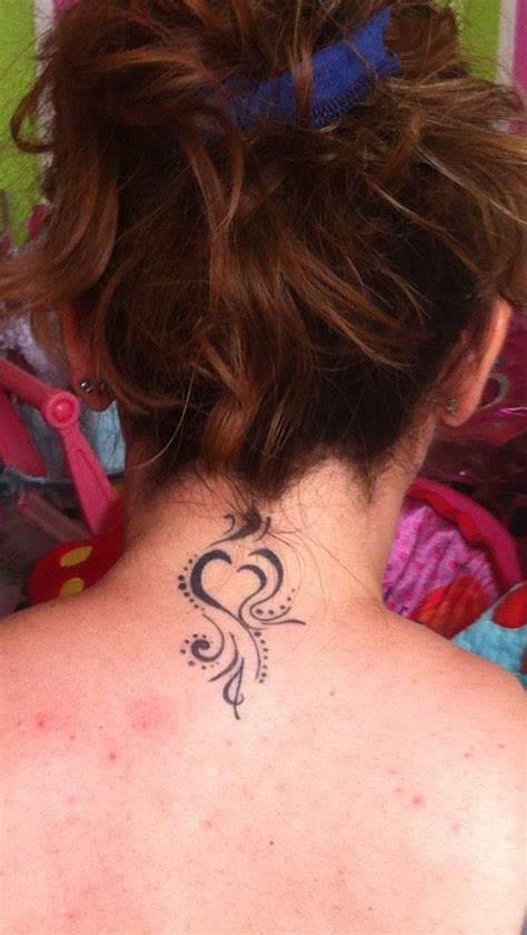A Woman With A Tattoo On Her Back Neck