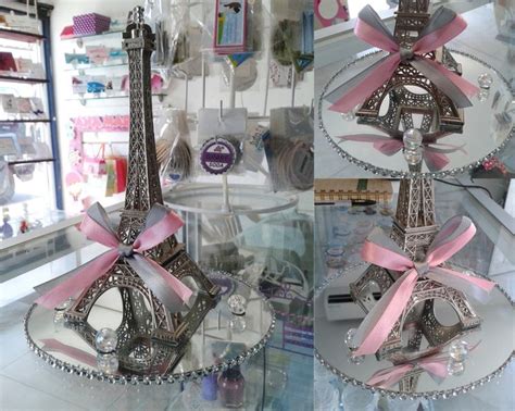 the eiffel tower has pink ribbons on it's display stand in front of a