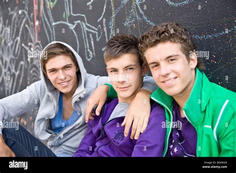 Drei Jungs Sitzen Nebeneinander Vor Einer Wand Nahaufnahme Stockfotografie Alamy